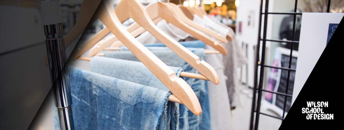 Row of jeans on hangers hanging up.