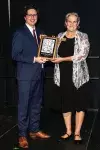Joan McEachern receiving her hall plaque from Saskatchewan Hall of Fame chair Trent Blezy