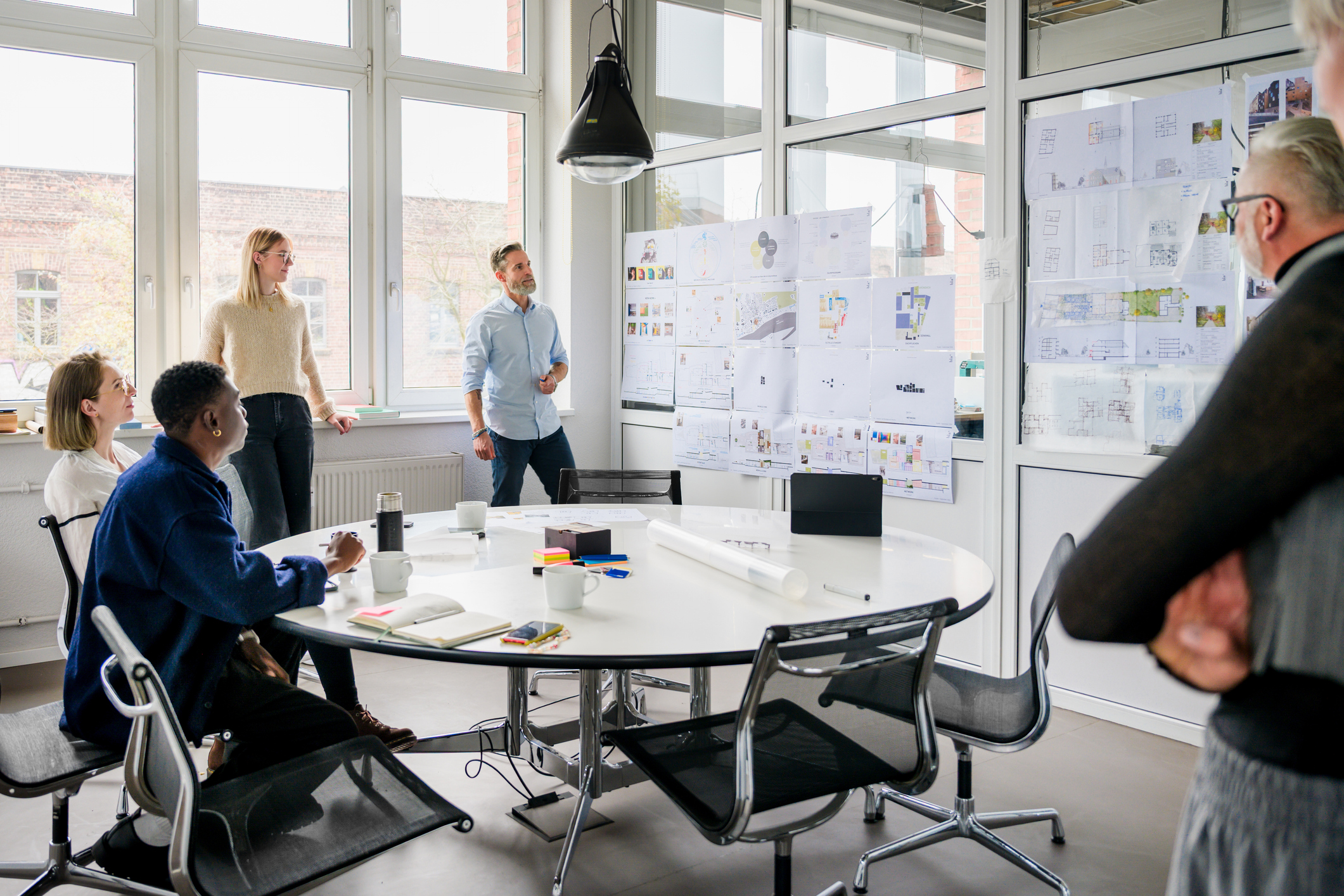 Boardroom of people looking at projects on a wall