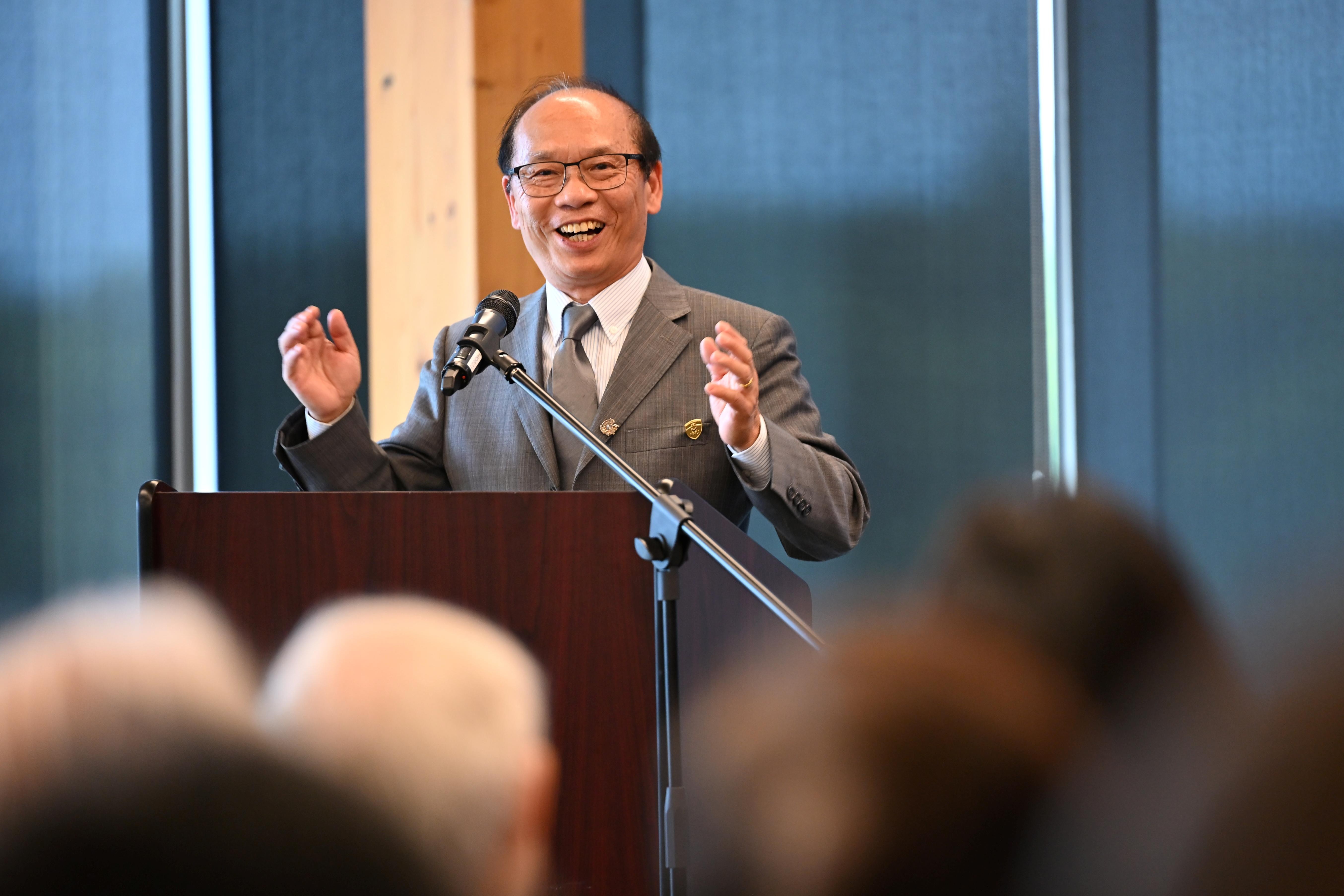 Dr. John Yang celebrates at the podium.