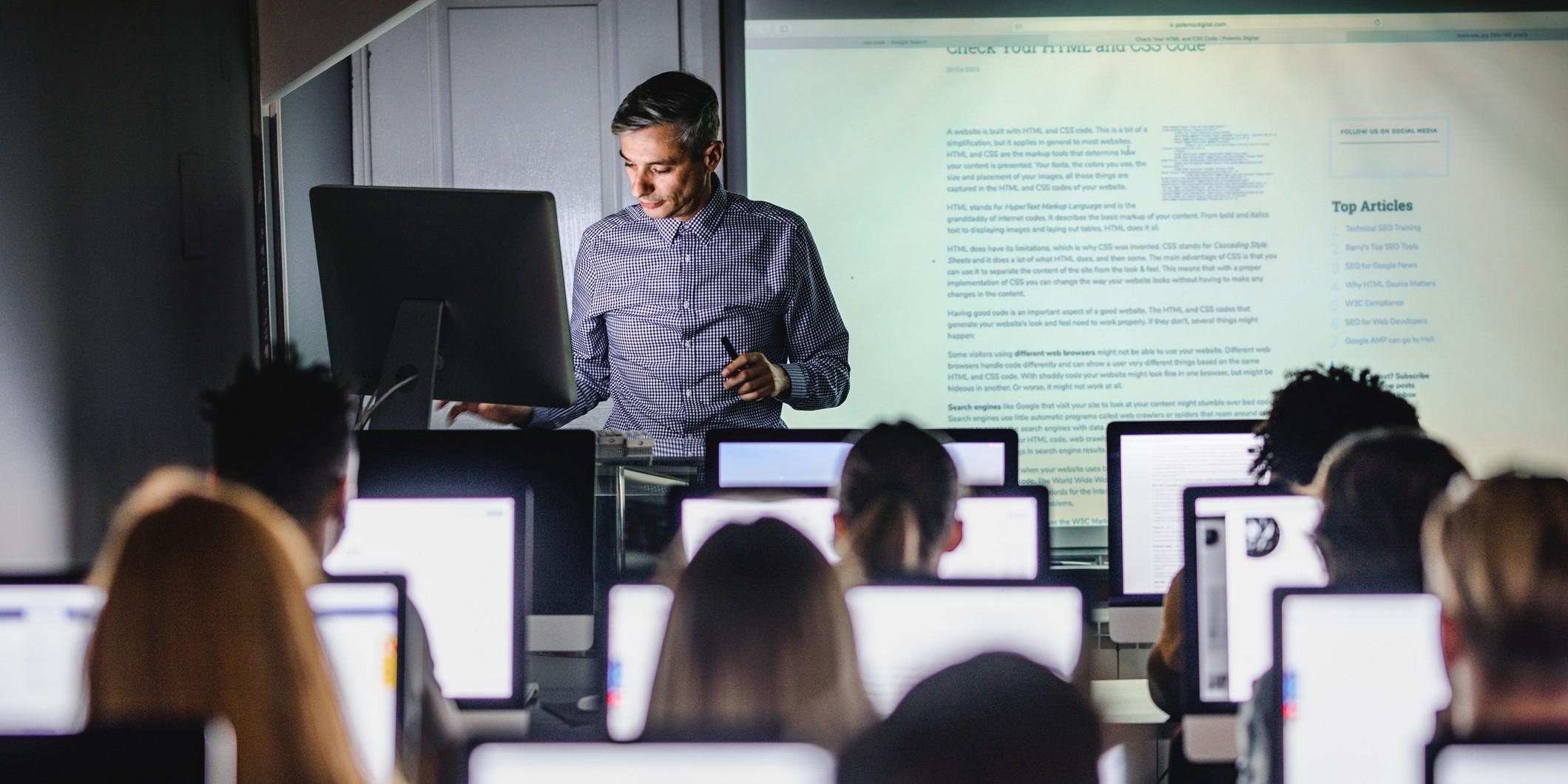 A professor presenting a lecture to students in a computer lab.