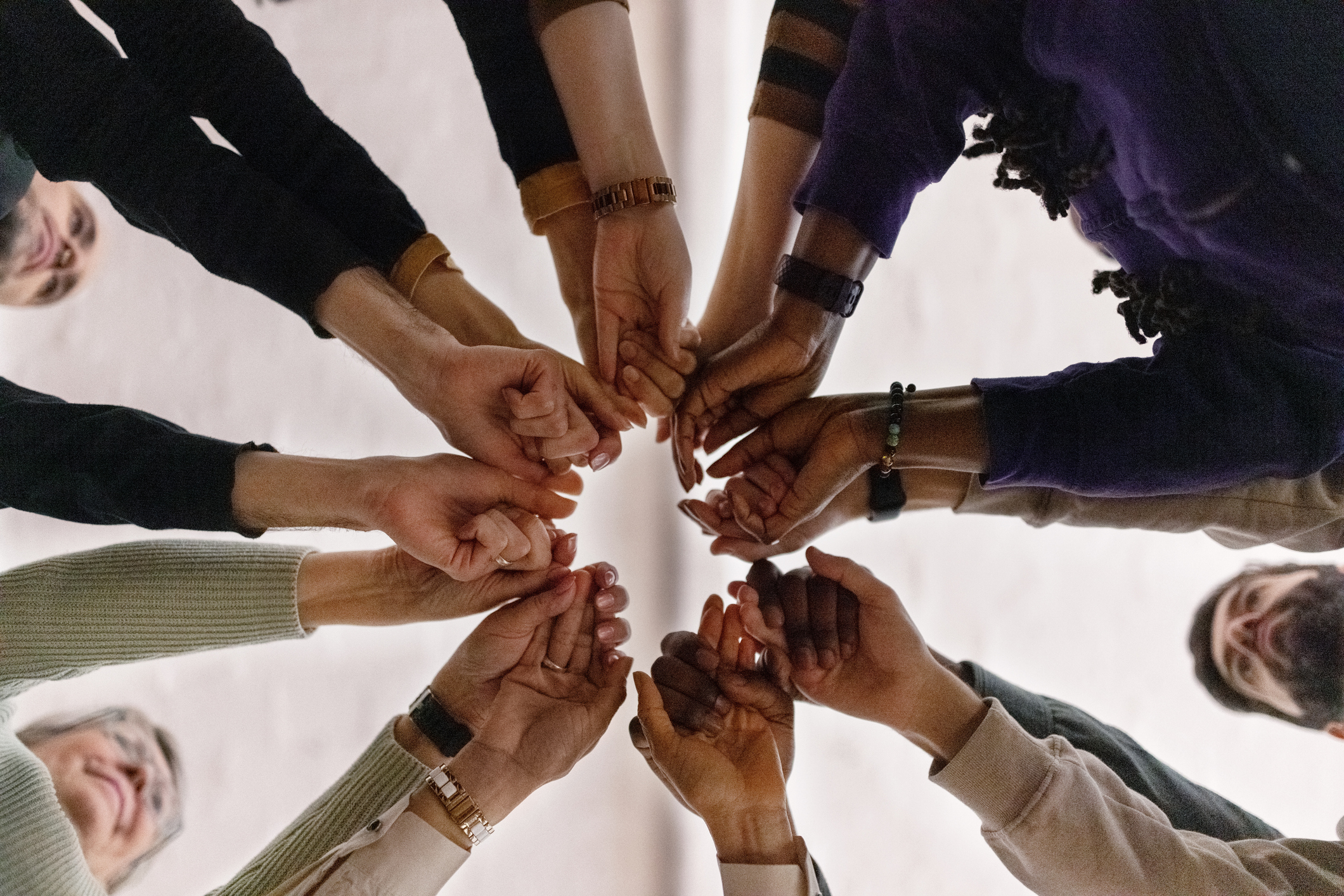 Group of people putting hands together in a circle
