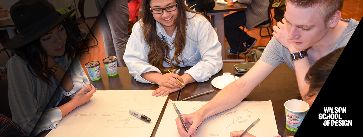 Three students brainstorm and sketch out ideas on the paper in front of them.