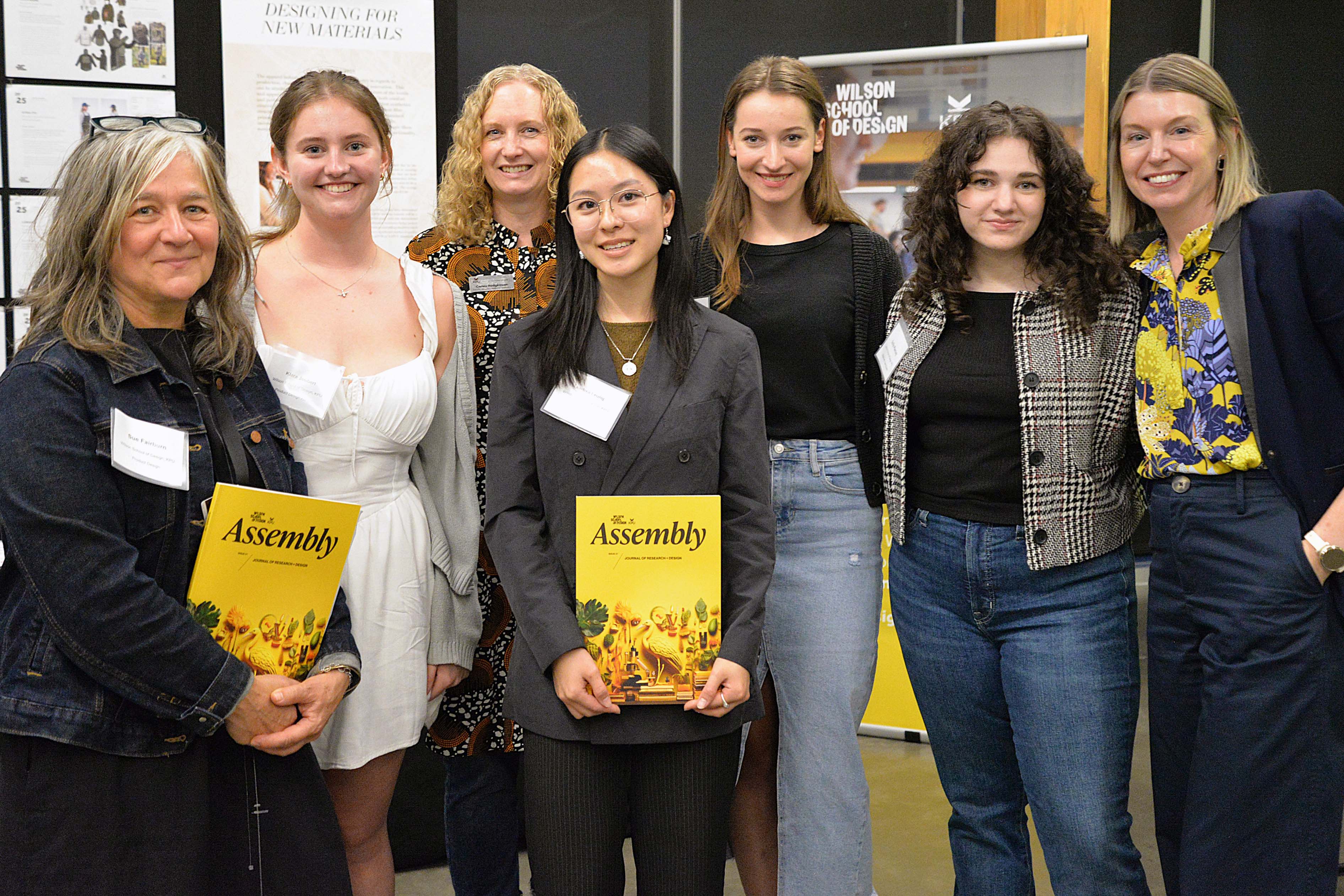 Group of people stand with copies of Assembly journal.