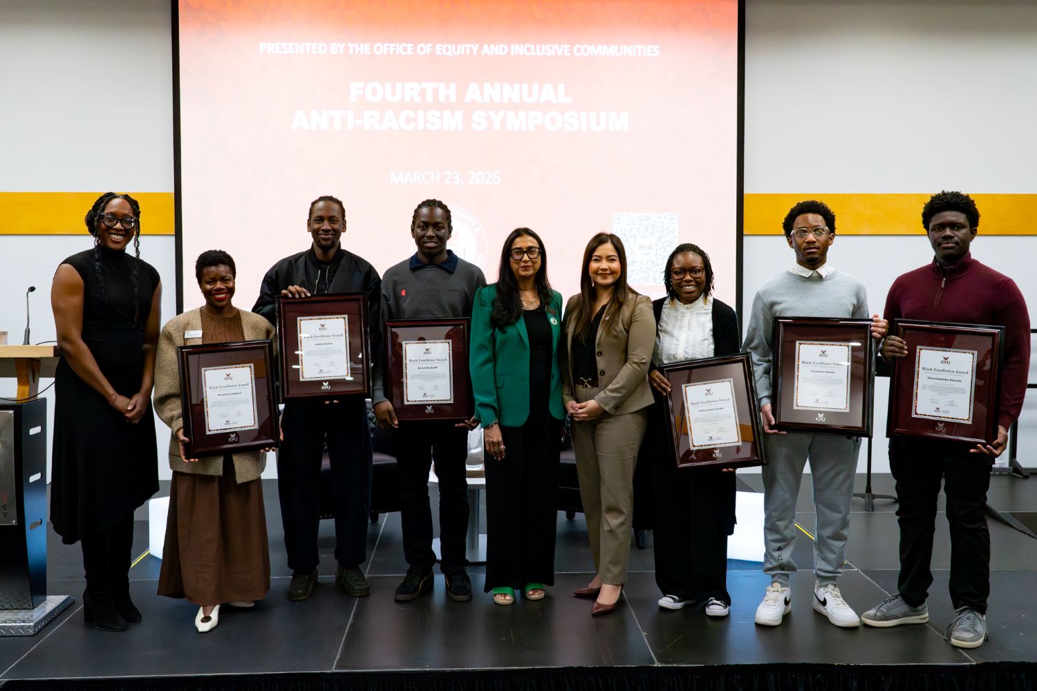 Award winners and presenters stand on stage.