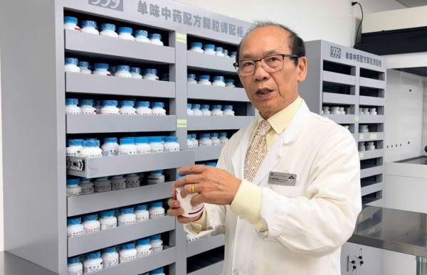 Dr. John Yang prepares herbs inside herbal dispensary.