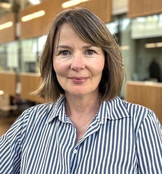 Woman with short, brown hair and a blue and white striped shirt
