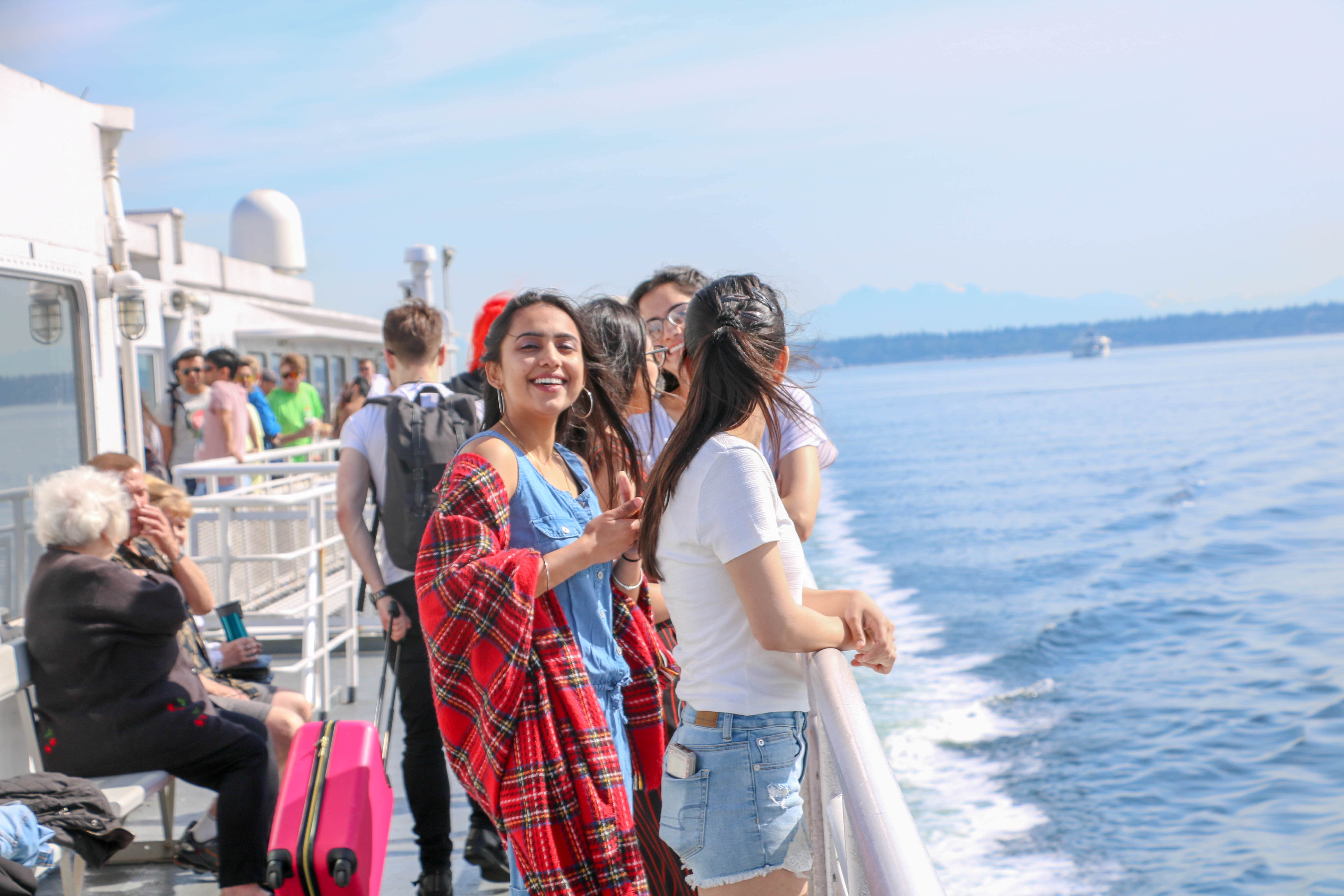 students smiling at camera on boat